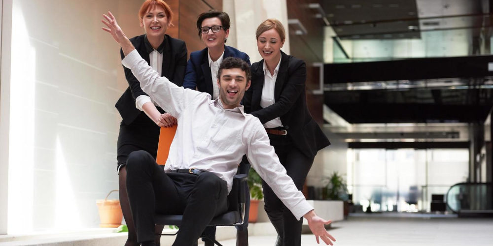 Corporate employees having fun on a chair with jazz hands